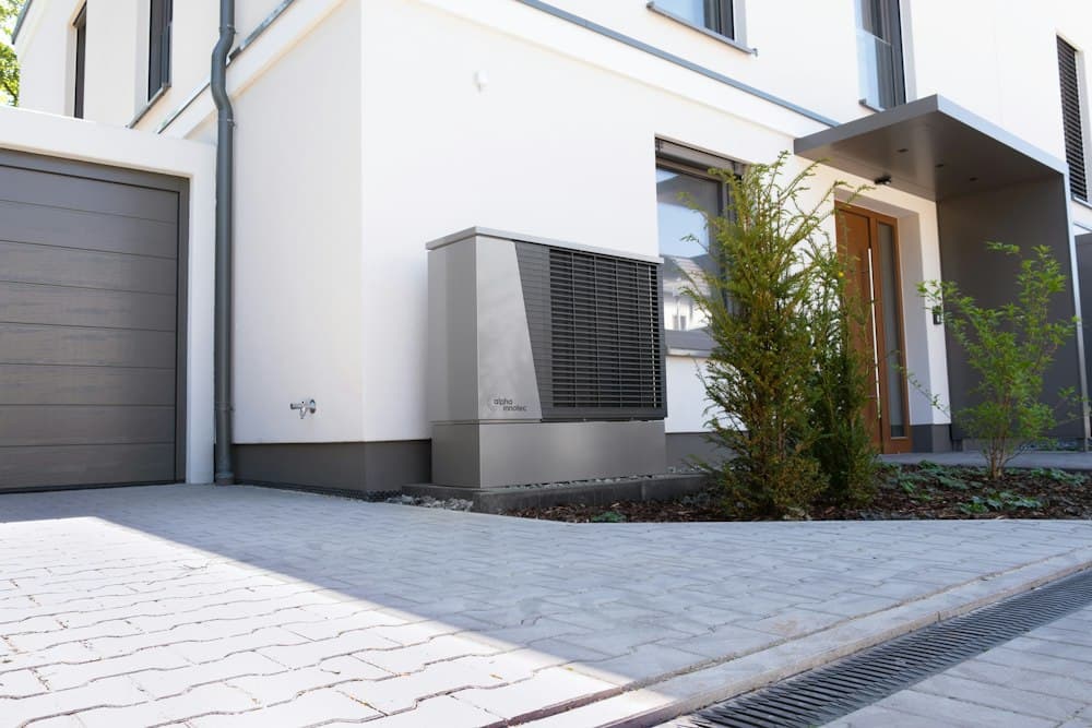 Pompe à chaleur devant une maison moderne près de Namur